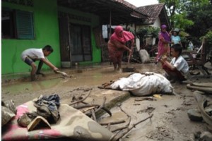 Pasca banjir, sejumlah warga membersihkan rumahnya dari lumpur.